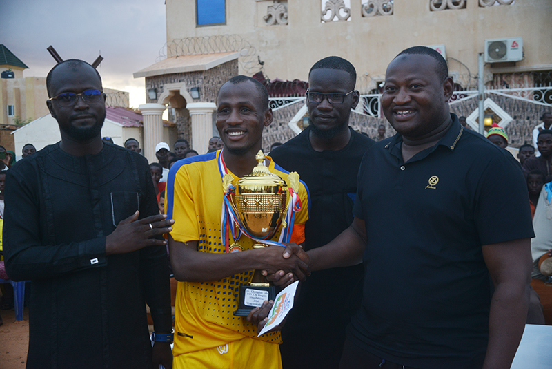 Le Capitaine de l'AS Cité du progès recevant le trophée