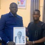 Almoustapha remettant une oeuvre à l'AD de Dosso