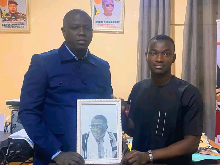 Almoustapha remettant une oeuvre à l'AD de Dosso